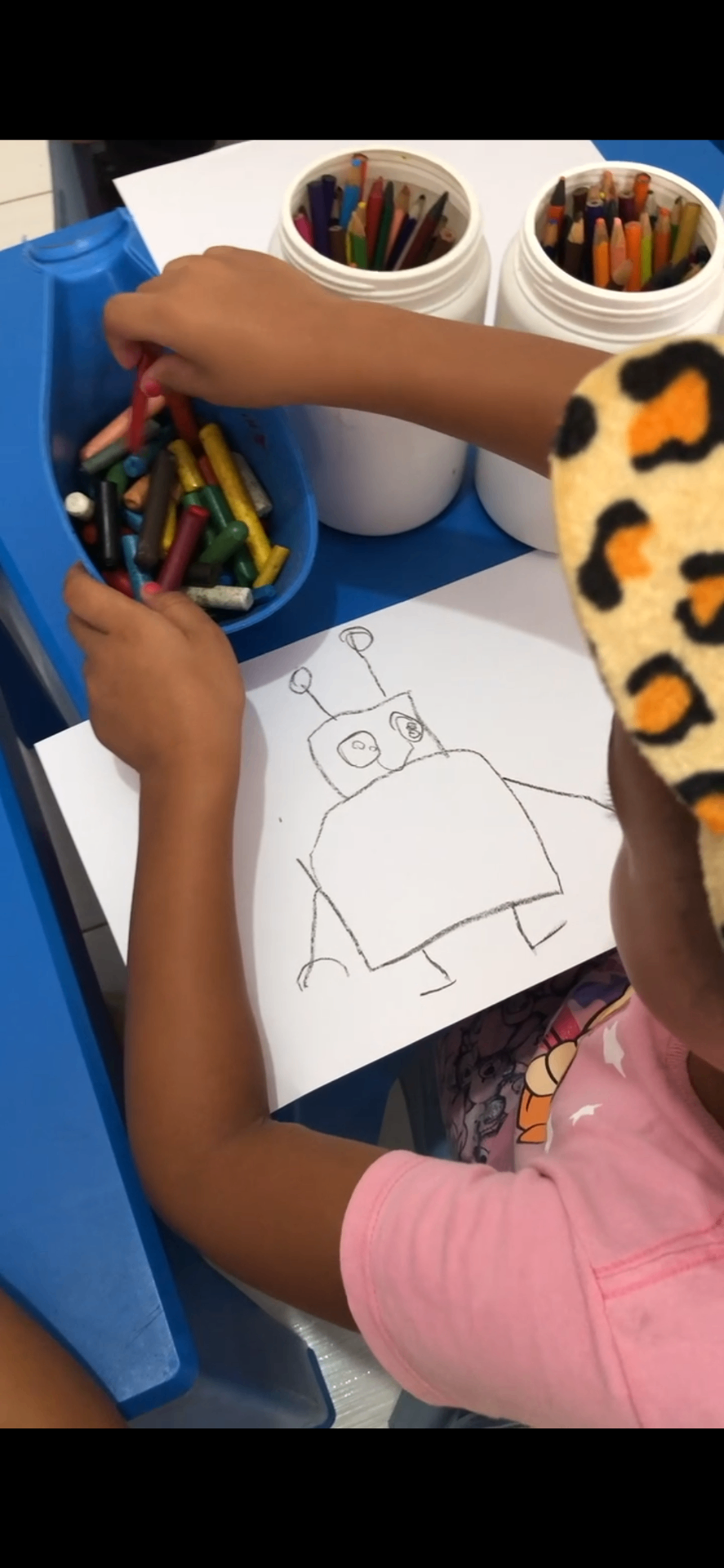 Aluna desenhando a ideia inicial de um robô durante a aula