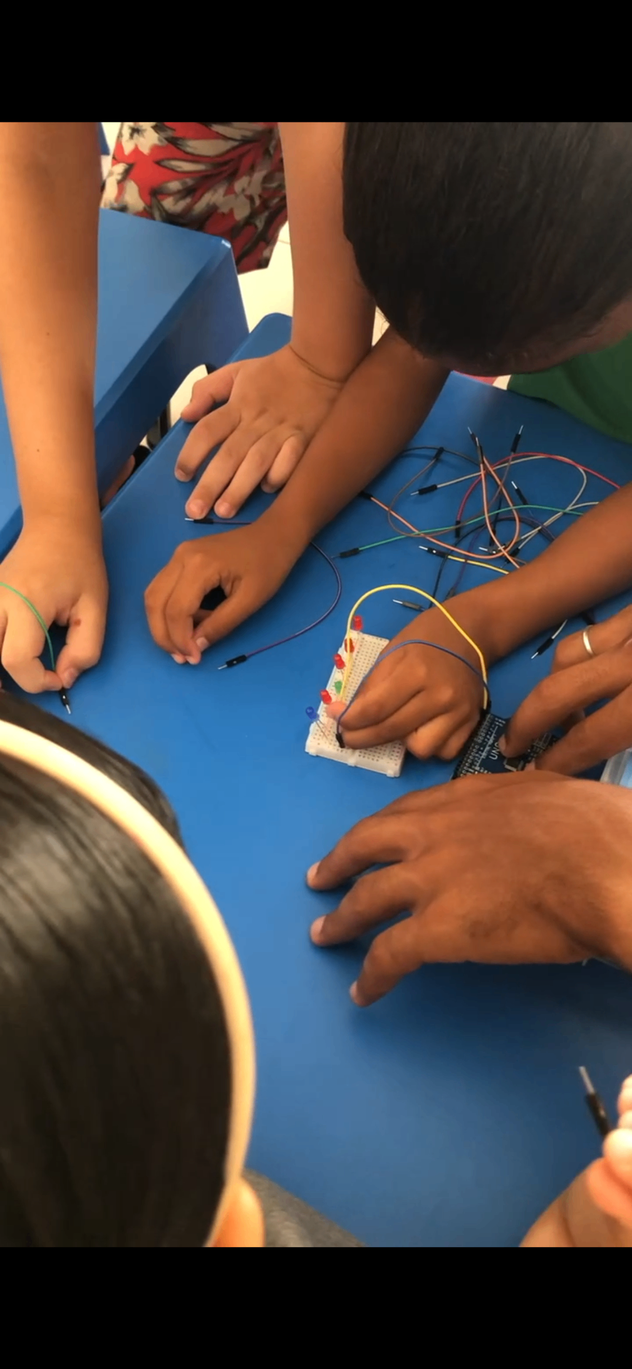 Turma montando um circuito eletrônico com LEDs e fios